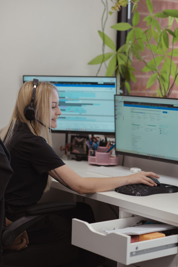 Three Guys Master Tradesmen CSR dispatcher assisting a customer while working at her desk
