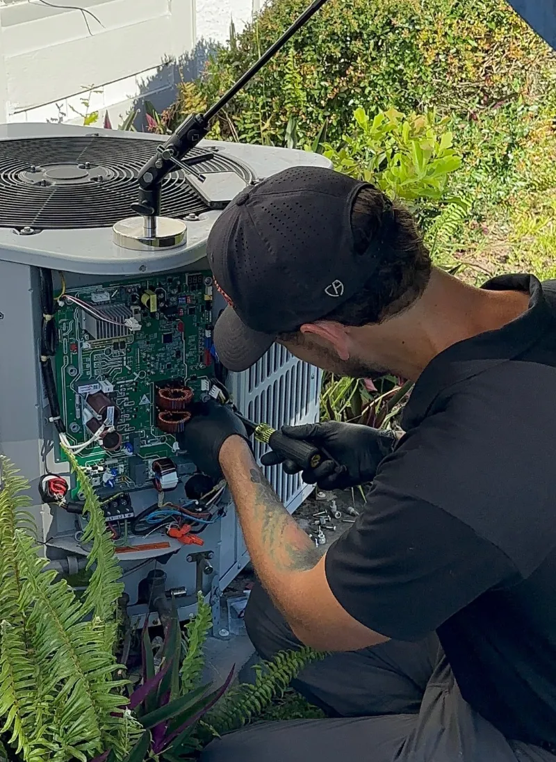 Three Guys technician replacing the control board on an outdoor AC condenser