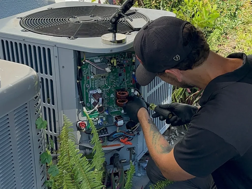 Three Guys technician replacing the control board on an outdoor AC condenser