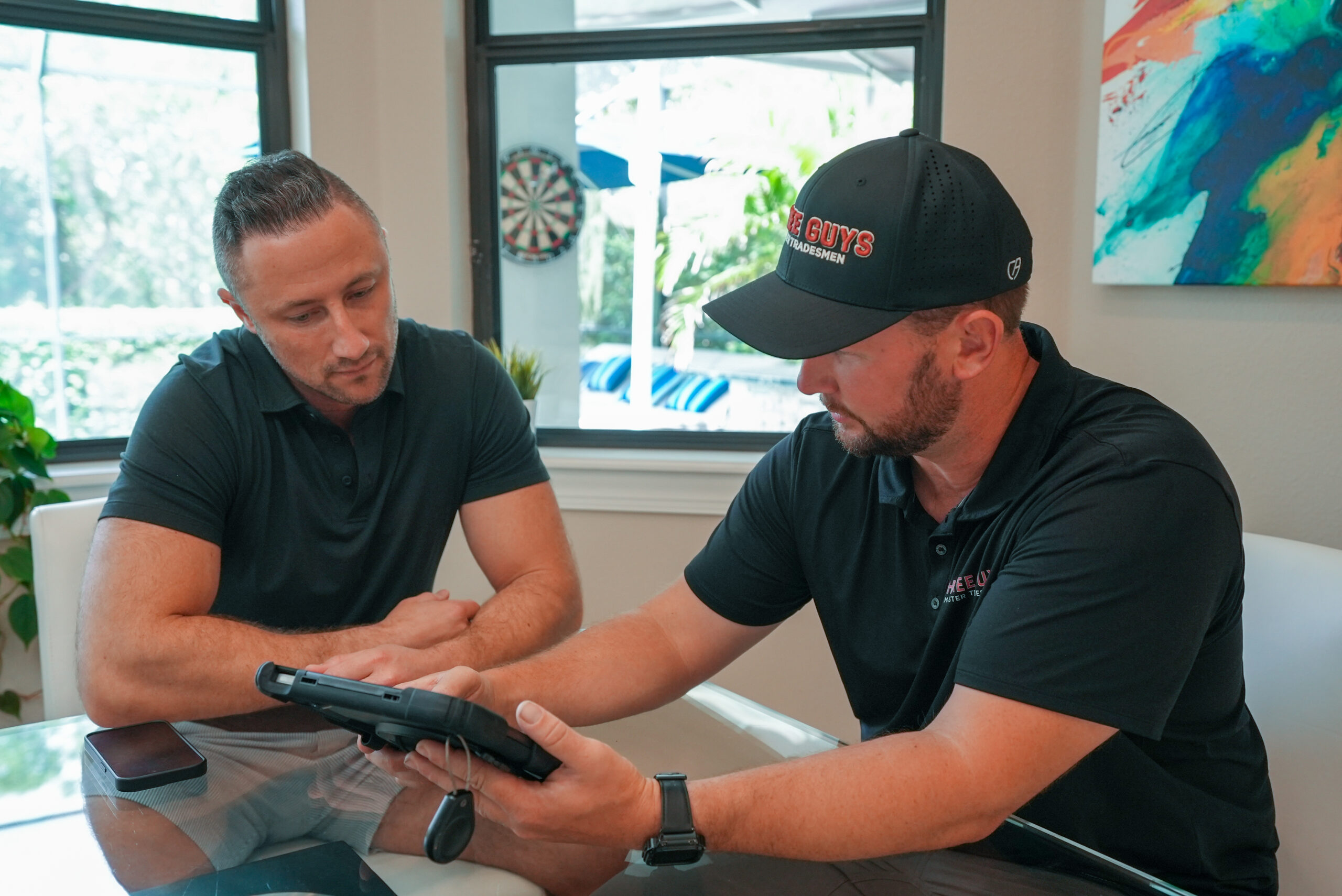 Three Guys Master Trades=men presenting options to homeowner on tablet